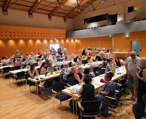Sommerfest der Hospizstiftung Rems-Murr-Kreis mit haupt- und ehrenamtlichen MitarbeiterInnen, die gemeinsam an Tischen in der Festhalle Murrhardt sitzen.
